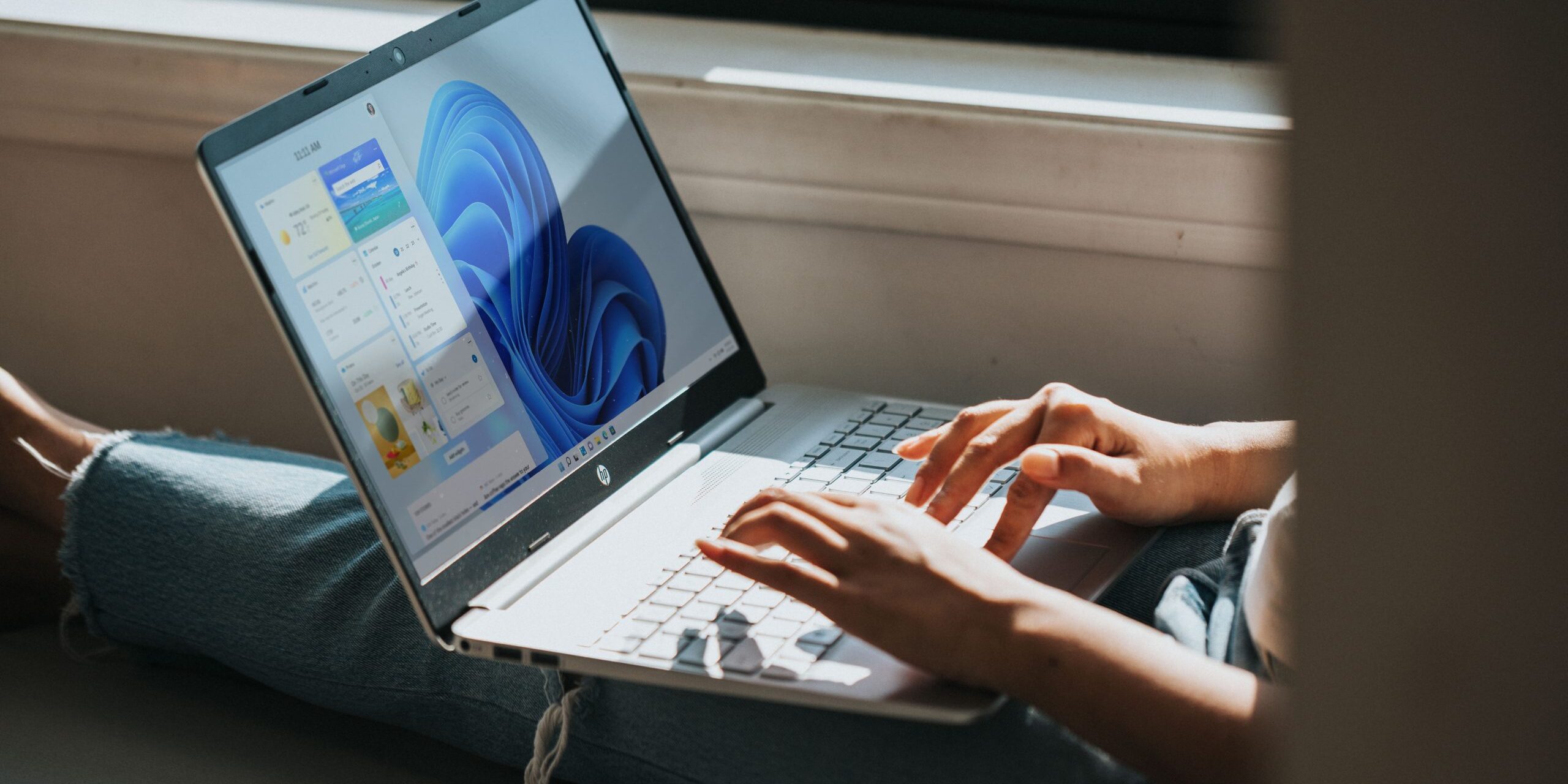 What-Are-the-Most-Helpful-Features-of-Windows-11-image-scaled.jpg person using Windows 11 computer on lap