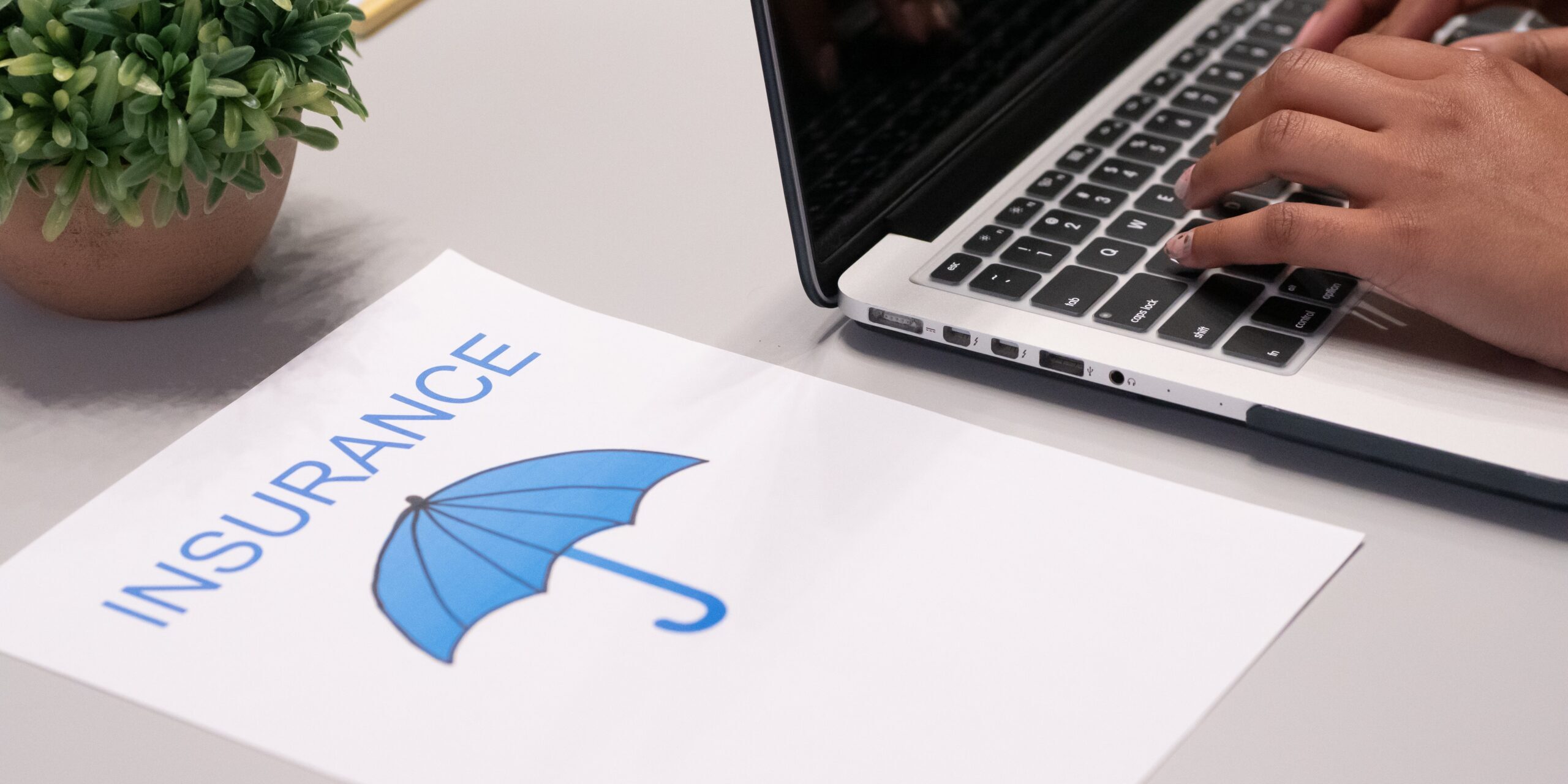Whats-Changing-in-the-Cybersecurity-Insurance-Market-scaled.jpg Free A Paper beside a Person Typing on a Laptop Stock Photo