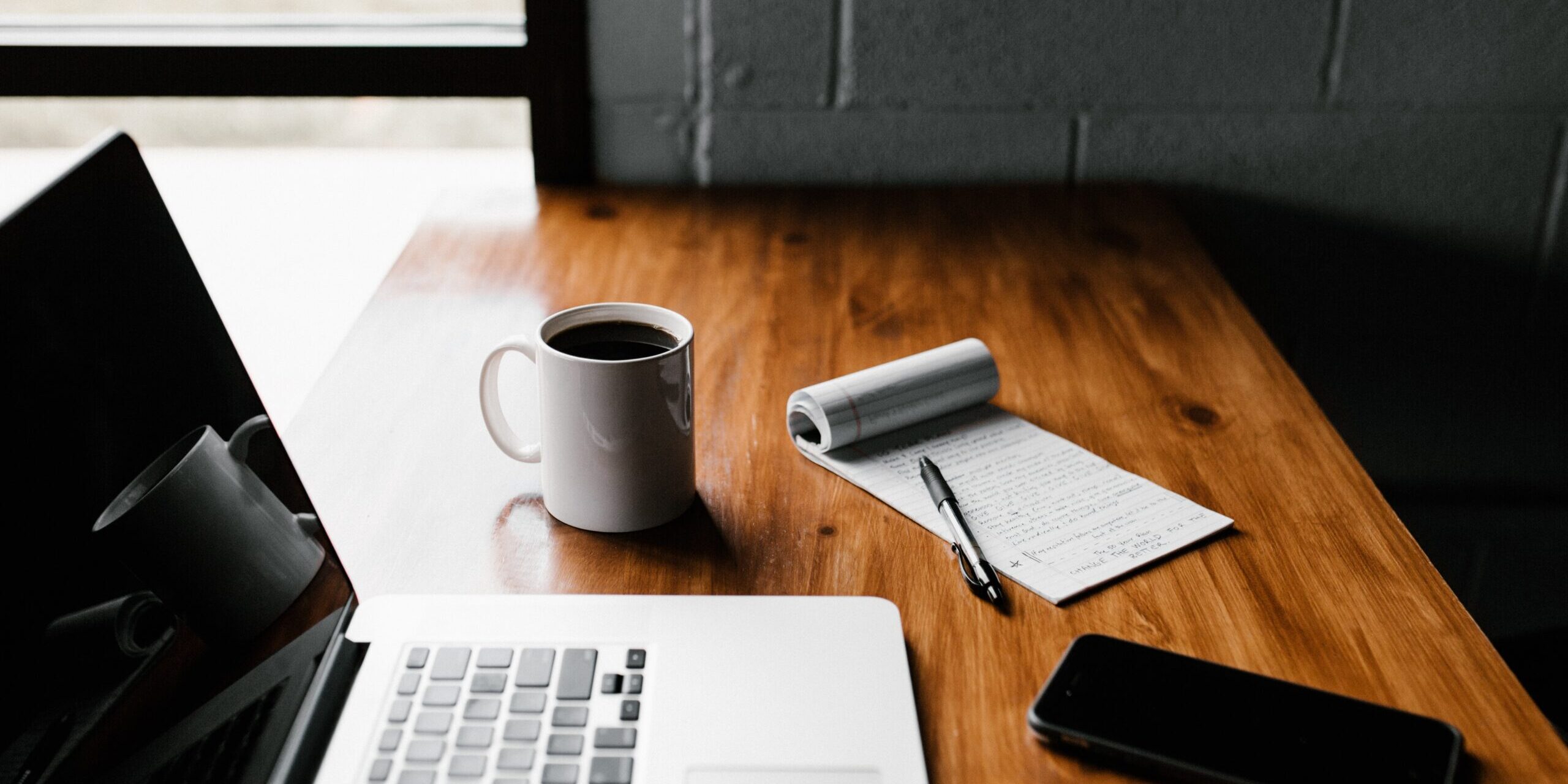 Handy-Checklist-for-Handling-Technology-Safely-During-a-Home-or-Office-Move-scaled.jpg MacBook Pro, white ceramic mug,and black smartphone on table