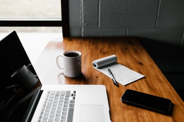 Handy-Checklist-for-Handling-Technology-Safely-During-a-Home-or-Office-Move-scaled.jpg MacBook Pro, white ceramic mug,and black smartphone on table