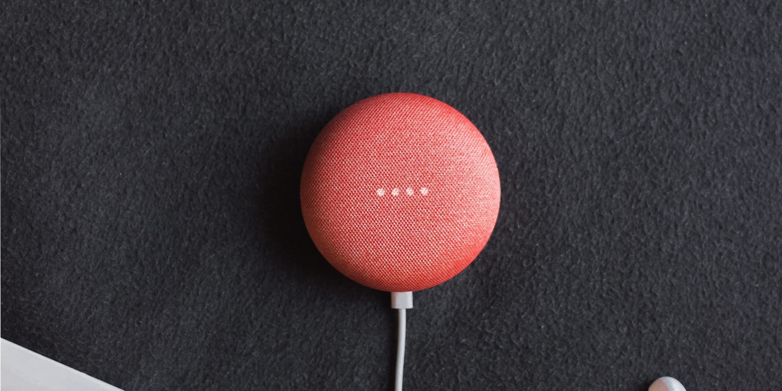 Are-Your-Smart-Home-Devices-Spying-On-You-Experts-Say-Yes-scaled.jpg flat lay photography of coral Google Home Mini on black surface beside Apple AirPods